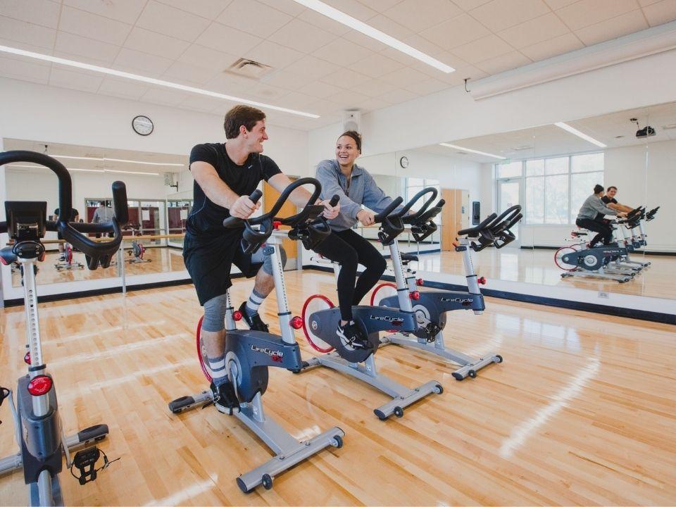Two students on exercise bikes in the Wellness Center 