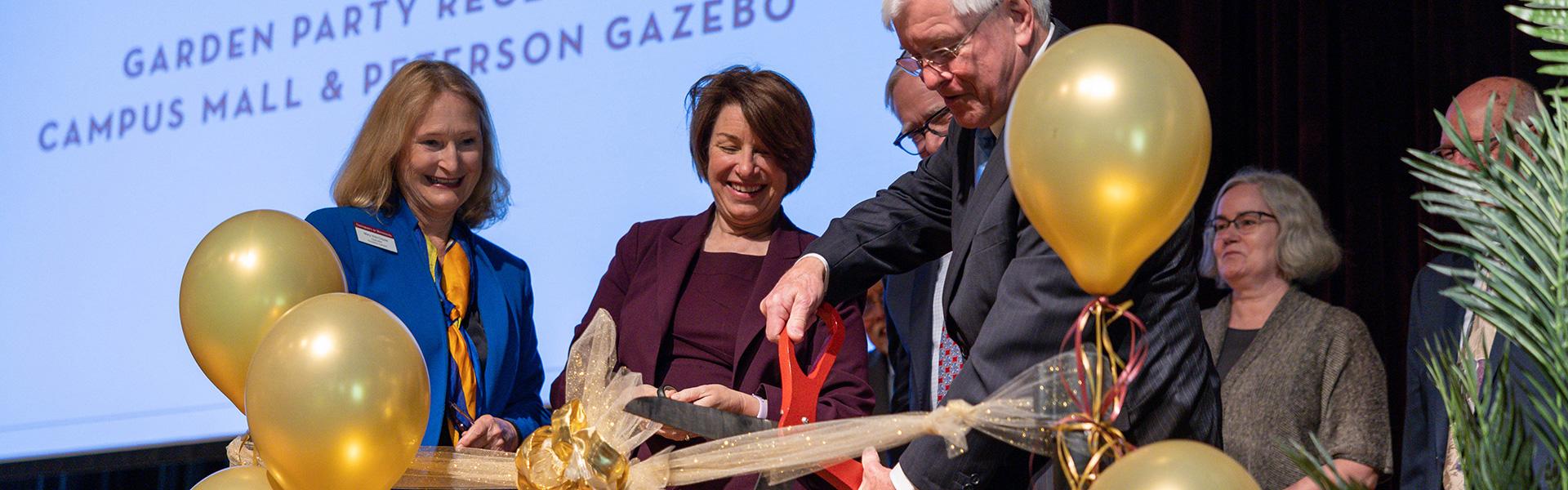Chancellor Mary Holz-Clause, Amy Klobuchar and Roger D. Moe cutting the ribbon during the Roger D. Moe Library Dedication in June 2023